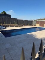Una piscina al aire libre, sillones reclinables de piscina