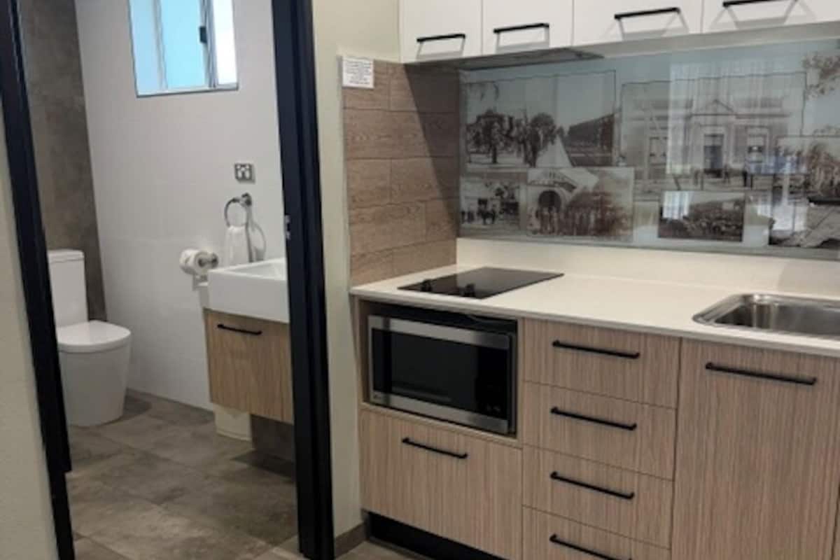 A modern kitchen with a built-in oven, a sink, and a window.
