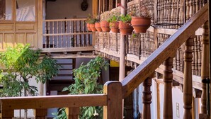 Un edificio tradizionale con tetto in tegole, balconi in legno e piante in vaso.