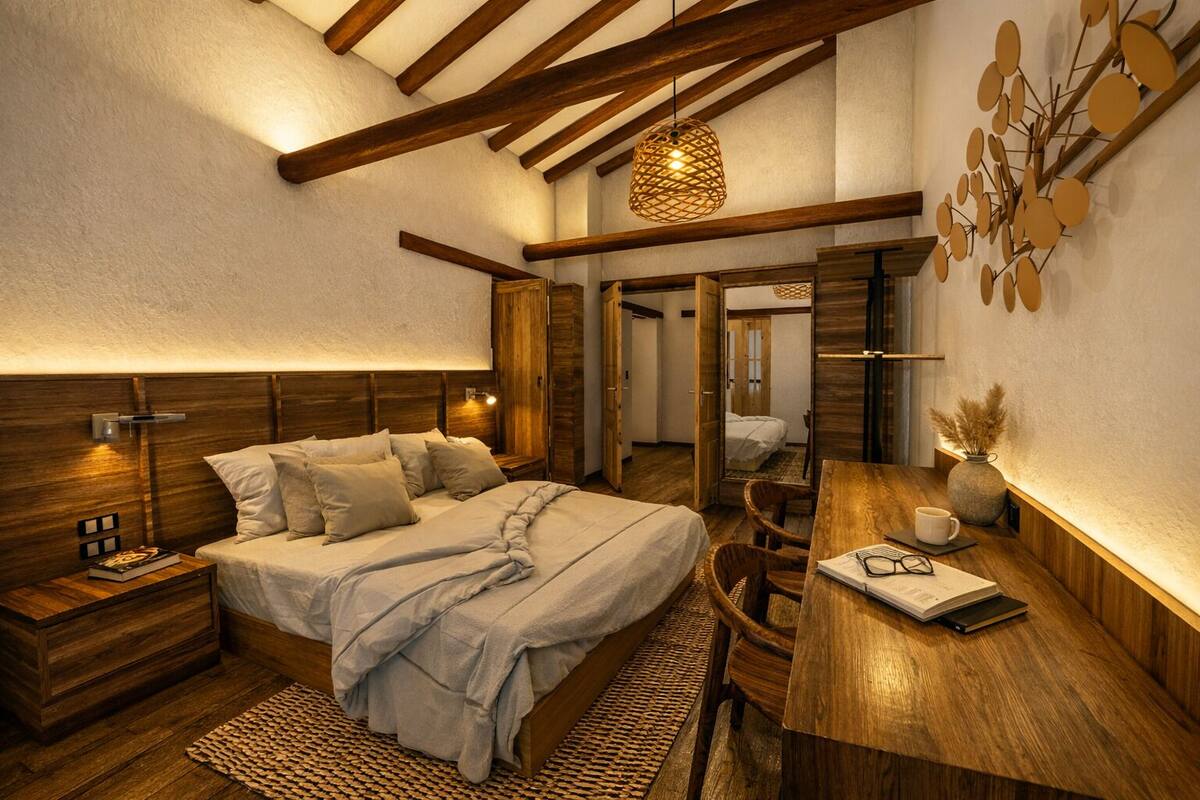 A bedroom with a bed, bedside tables, a desk, and a mirror.
