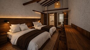 Una camera da letto con due letti, travi in legno, un lampadario e una piccola scrivania.