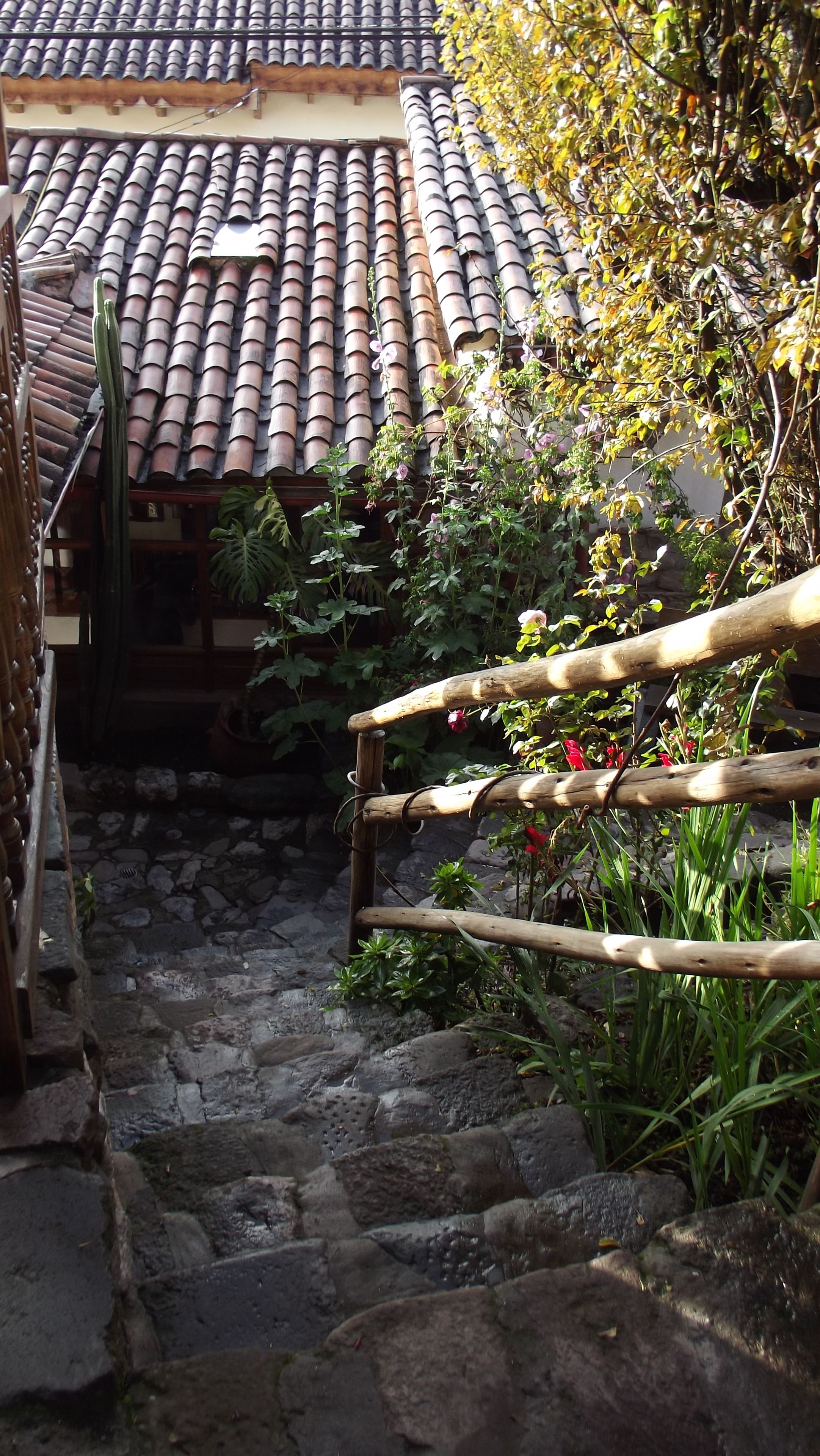 Una escalera de piedra que lleva a una casa tradicional con techo de tejas.