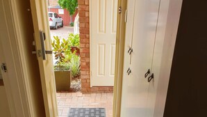 A hallway with a tiled floor leading to a door. - Australian Heritage Motor Inn (Dubbo)