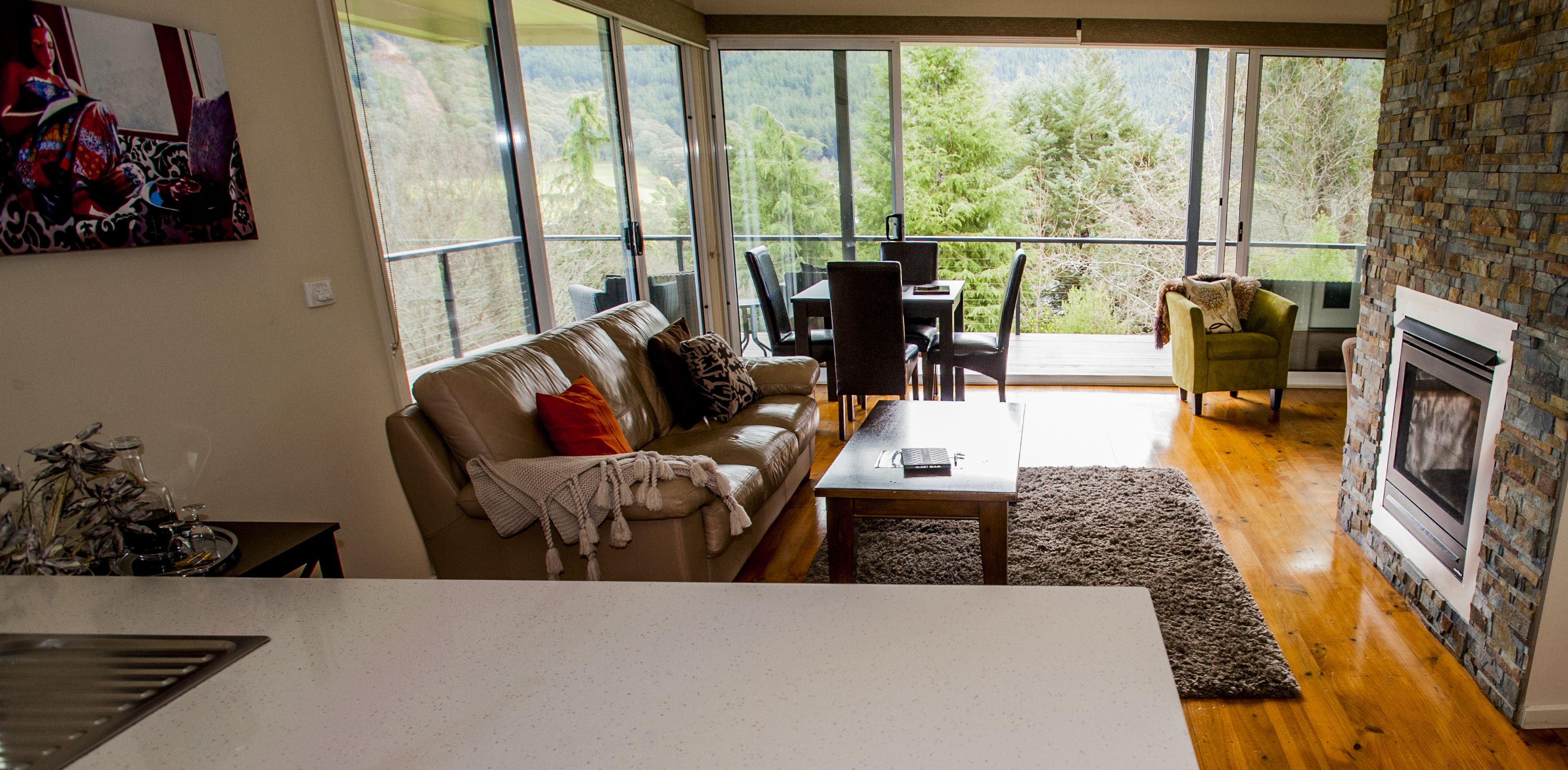A spacious living room with a large window, a fireplace, and a cozy seating area.
