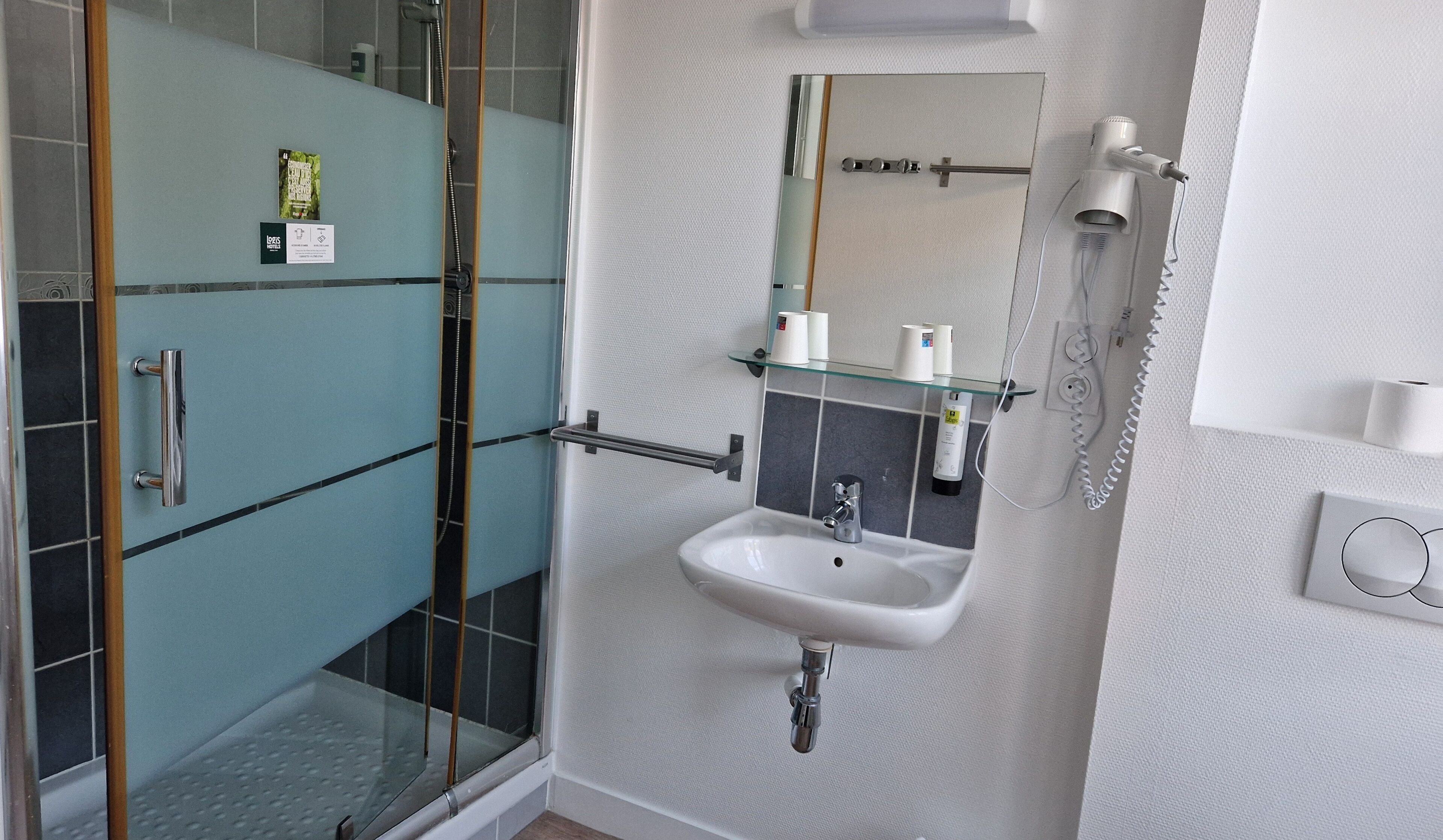 Une salle de bain avec une douche à parois de verre, un lavabo et un miroir.