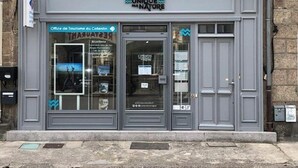 Vitrine com placa exibindo a inscrição "COTENTIN UNIQUE PAR NATURE" e um cartaz na janela.