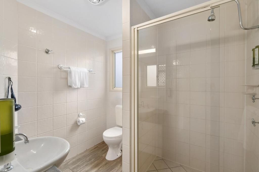 A bathroom with a sink, toilet, and shower.