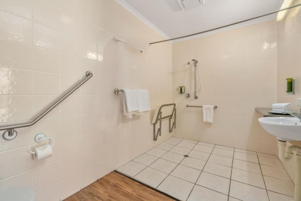 A bathroom with a shower, toilet, and sink.