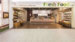 A Fresh Food Café with a central counter displaying various food items and a menu board on the left. - Days Inn by Wyndham Taunton (Taunton)