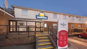 A Days Inn hotel with a visible entrance, a staircase leading to the entrance, and a sign for Regus Express Workspace. - Days Inn by Wyndham Watford Gap (Northampton)