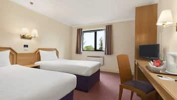 Een hotelkamer met twee bedden, een bureau met stoel, een televisie en een raam met gordijnen.