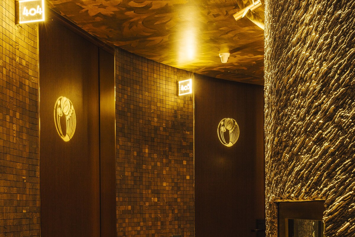 Eine Hotelhalle mit einem gewölbten Marmorboden, Holztüren und einer strukturierten Wand.