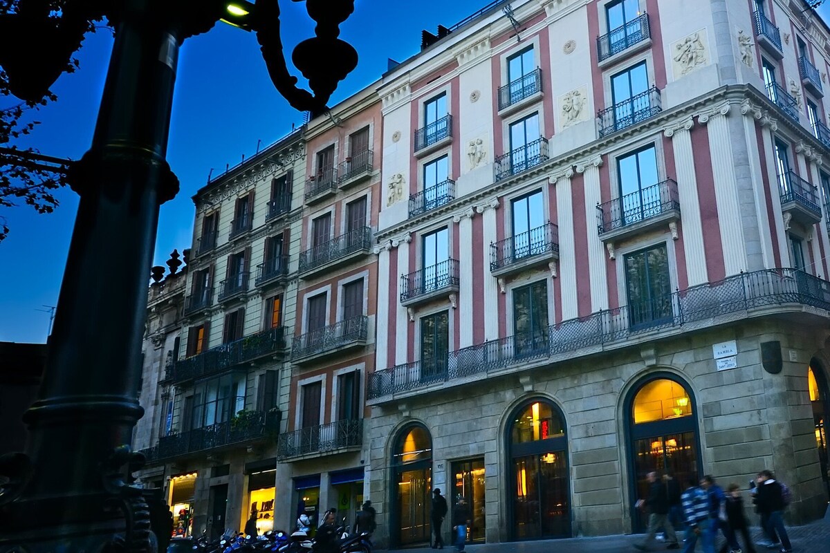 Ein historisches Gebäude mit mehreren Balkonen und Rundbogenfenstern, vermutlich ein Hotel oder ein öffentliches Gebäude.