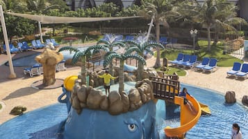 Enjoy a thrilling water slide experience surrounded by a pool and lush palm trees.