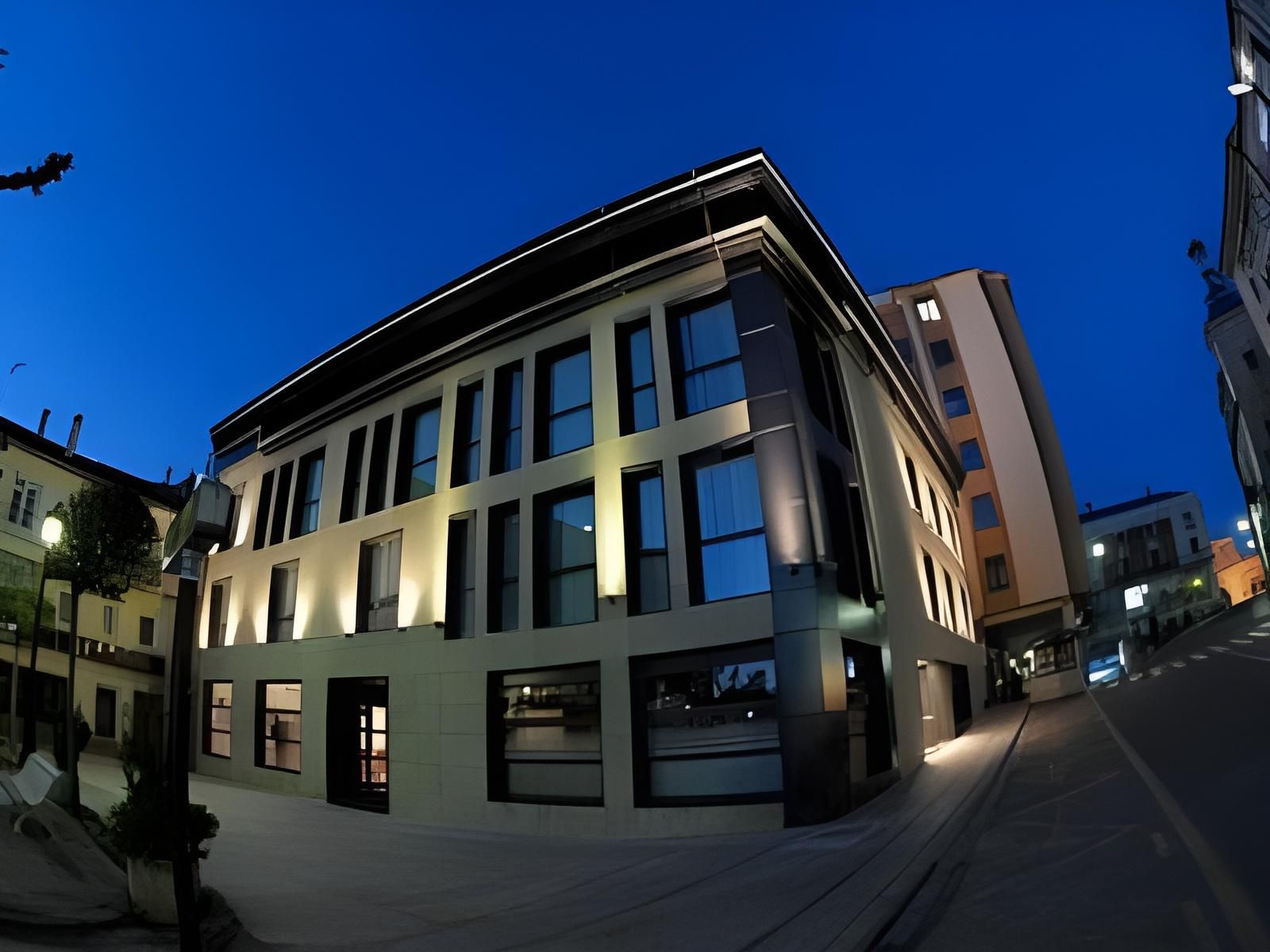 A modern building with a flat roof, large windows, and a corner entrance.