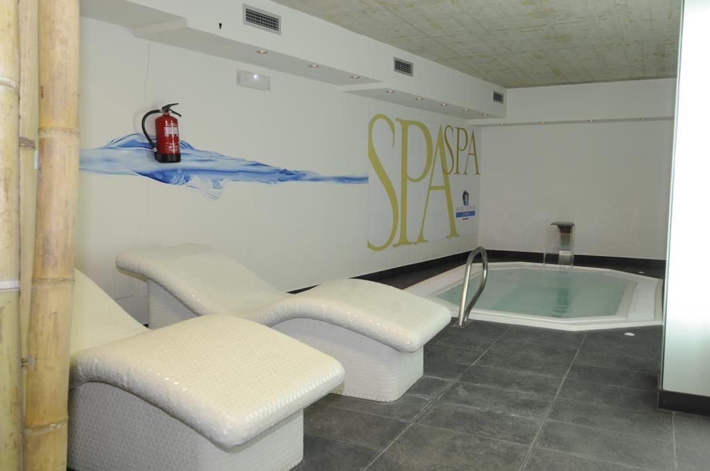 Zona de spa con dos sillones reclinables, un jacuzzi y un extintor colgado en la pared.