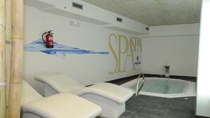 A spa area with two lounge chairs, a hot tub, and a wall-mounted fire extinguisher. - Hotel Alameda Centro (Soria)