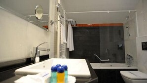 Casa de banho moderna com lavatório, espelho e banheira.