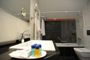 Une salle de bain moderne avec un lavabo, un miroir et une baignoire.