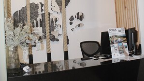 Un mostrador de recepción de diseño moderno, con una superficie de vidrio y un panel de madera a la derecha.