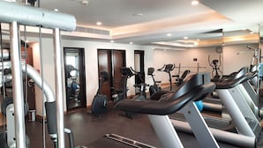 Un gimnasio con cintas de correr, elípticas y máquinas de pesas.