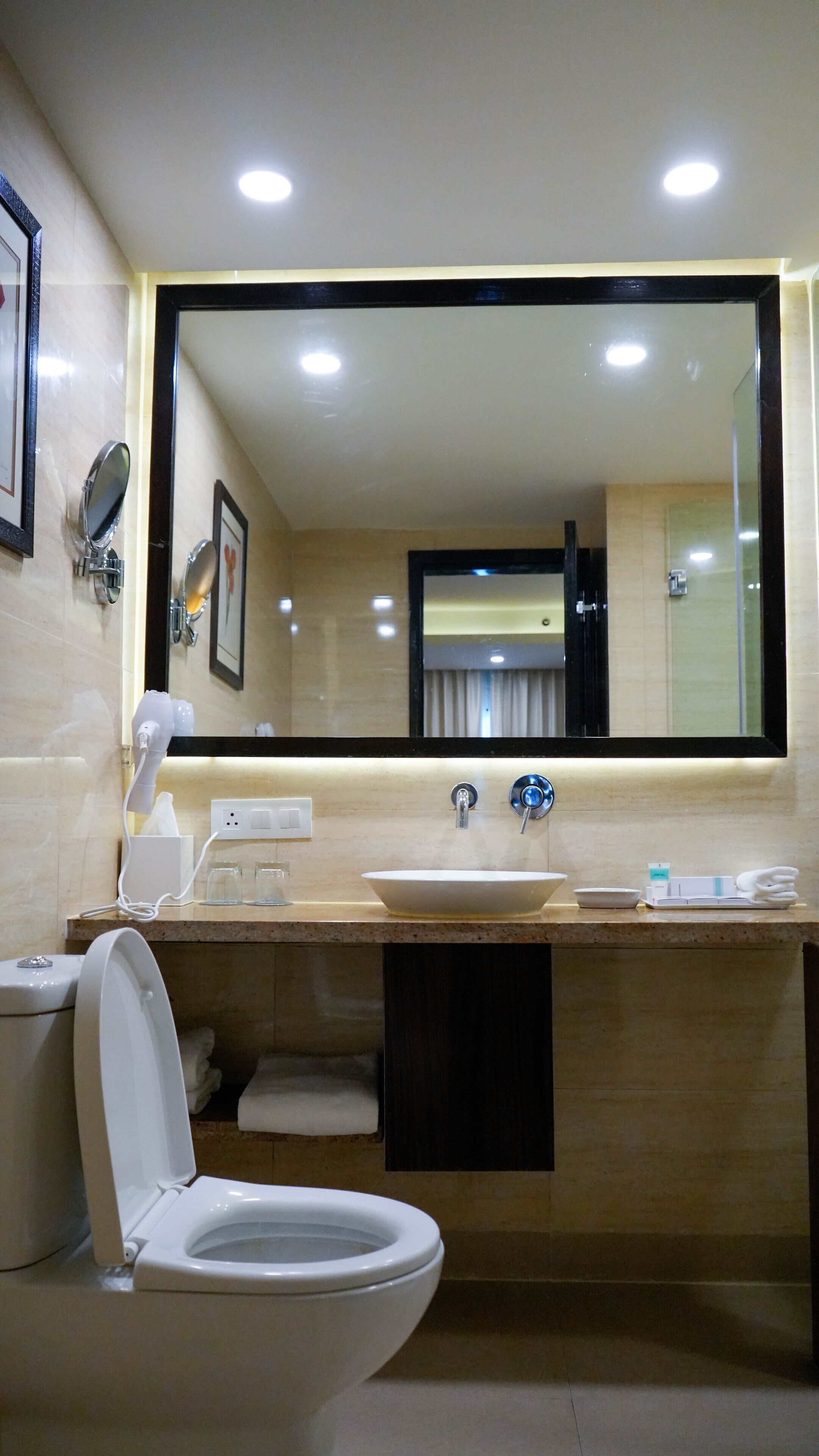 A modern bathroom with a toilet, sink, and mirror.