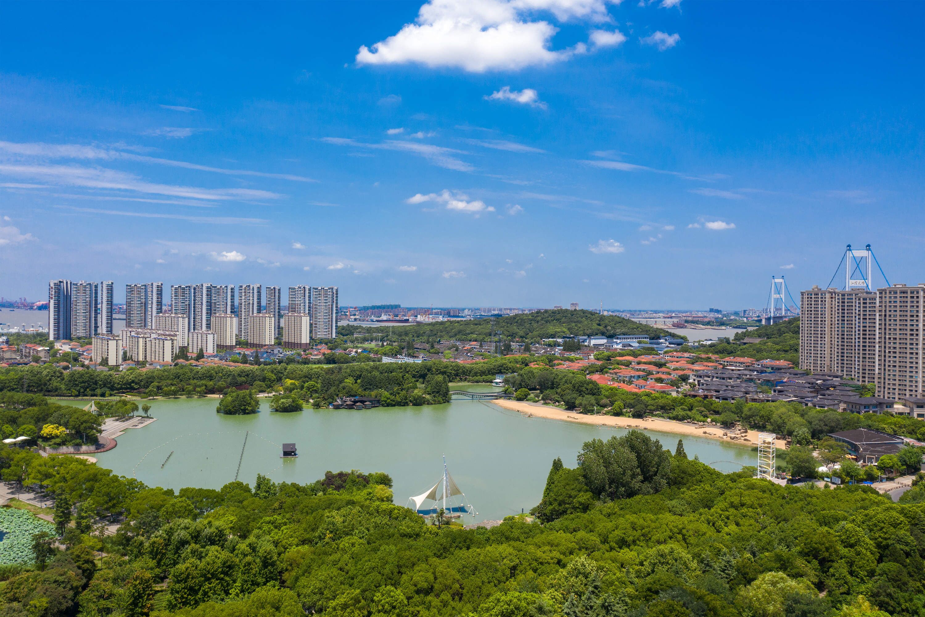 Eine Skyline mit Hochhäusern, einem Fluss und einem Park mit einem Boot.