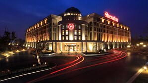 Un hotel Sheraton con una cúpula destacada y señalización iluminada.