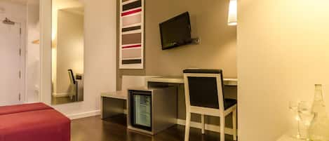 Une chambre moderne équipée d’un bureau, d’une chaise et d’un petit réfrigérateur.