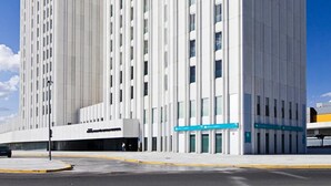 A modern, white hotel with a prominent vertical design and a sign indicating it is a Marriott hotel.