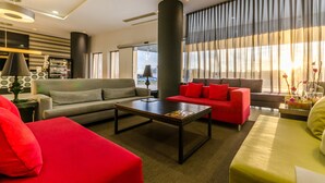 A modern living room with a grey sofa, red armchair, and a coffee table.