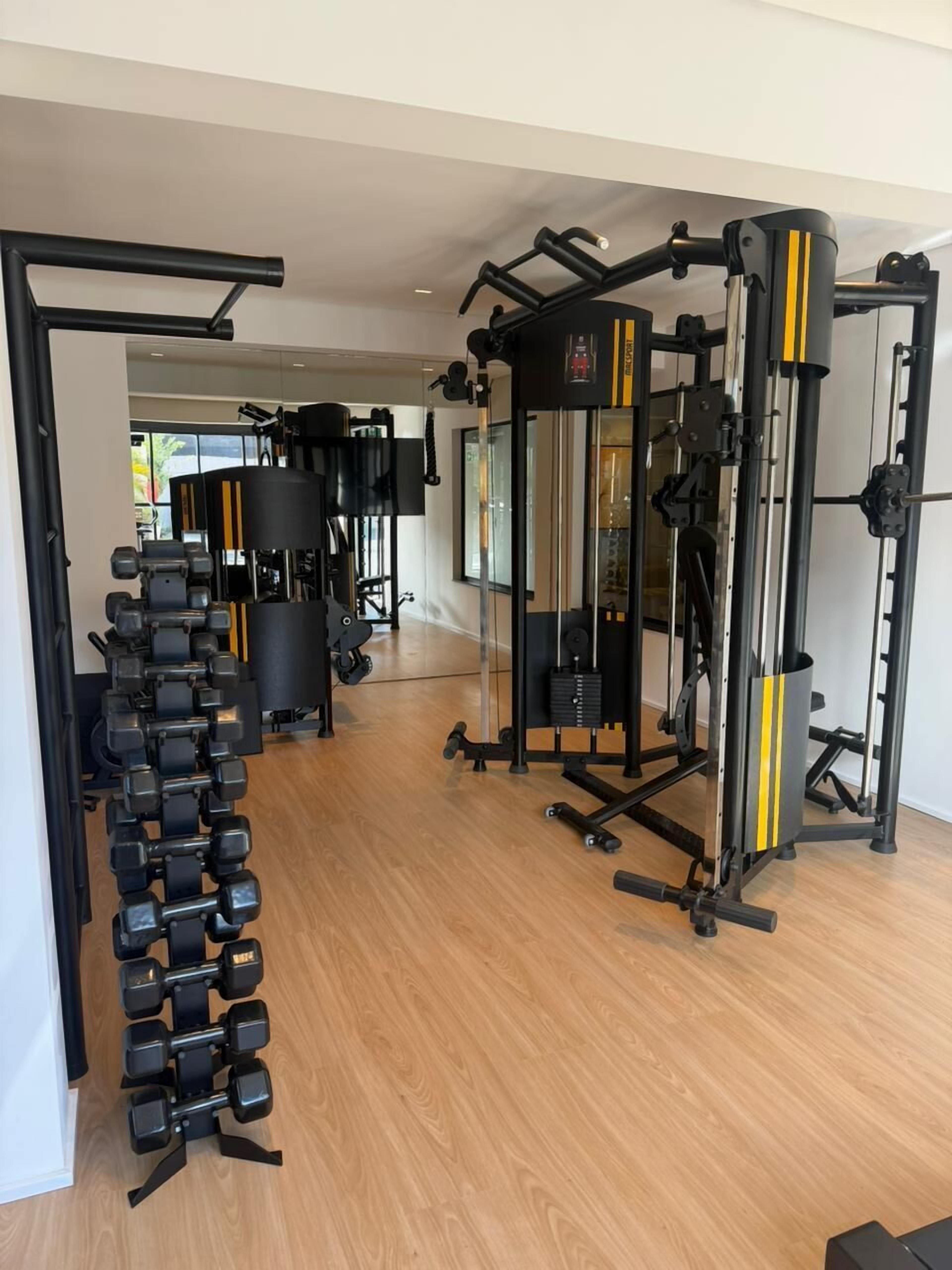 A gym with various exercise equipment, including dumbbells and weight machines.