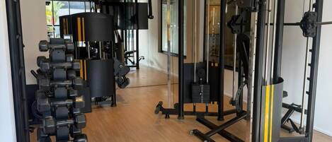 Uma academia com diversos equipamentos de exercício, incluindo halteres e aparelhos de musculação.