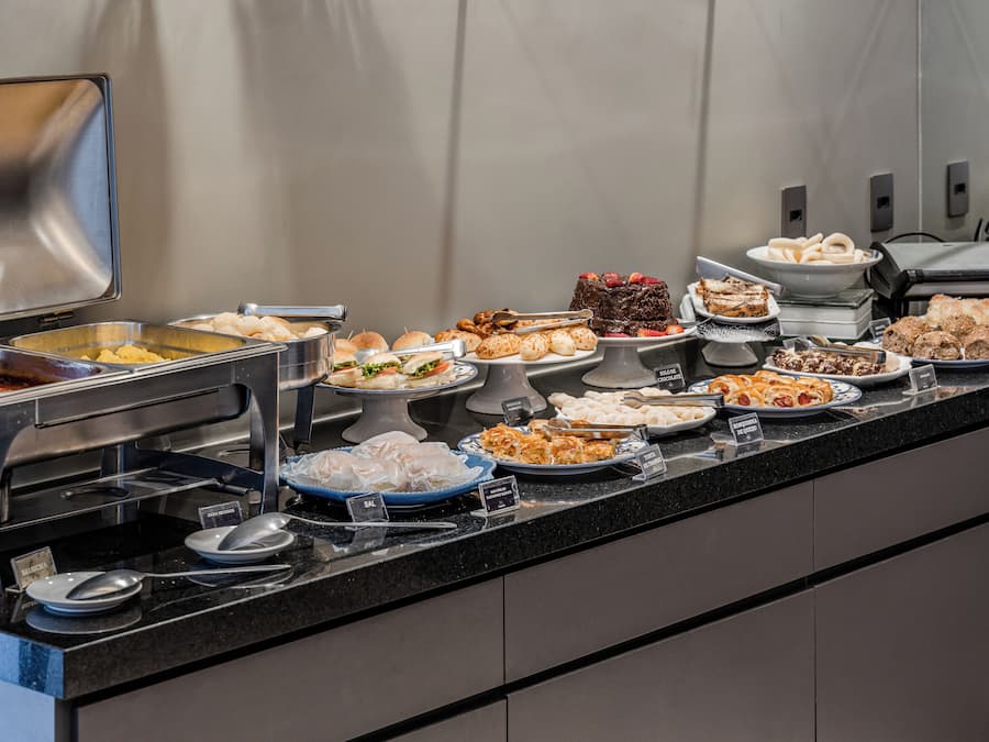 Buffet com diversos alimentos e utensílios.