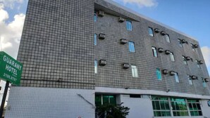 A multi-story hotel with a grid-patterned facade, air conditioning units, and a sign for the GUARANY HOTEL. - Guarany Hotel Express (João Pessoa)