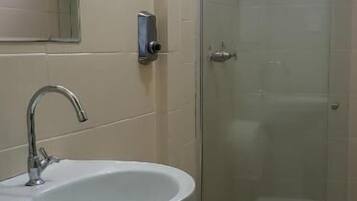 A bathroom with a pedestal sink, a toilet, and a glass shower enclosure.