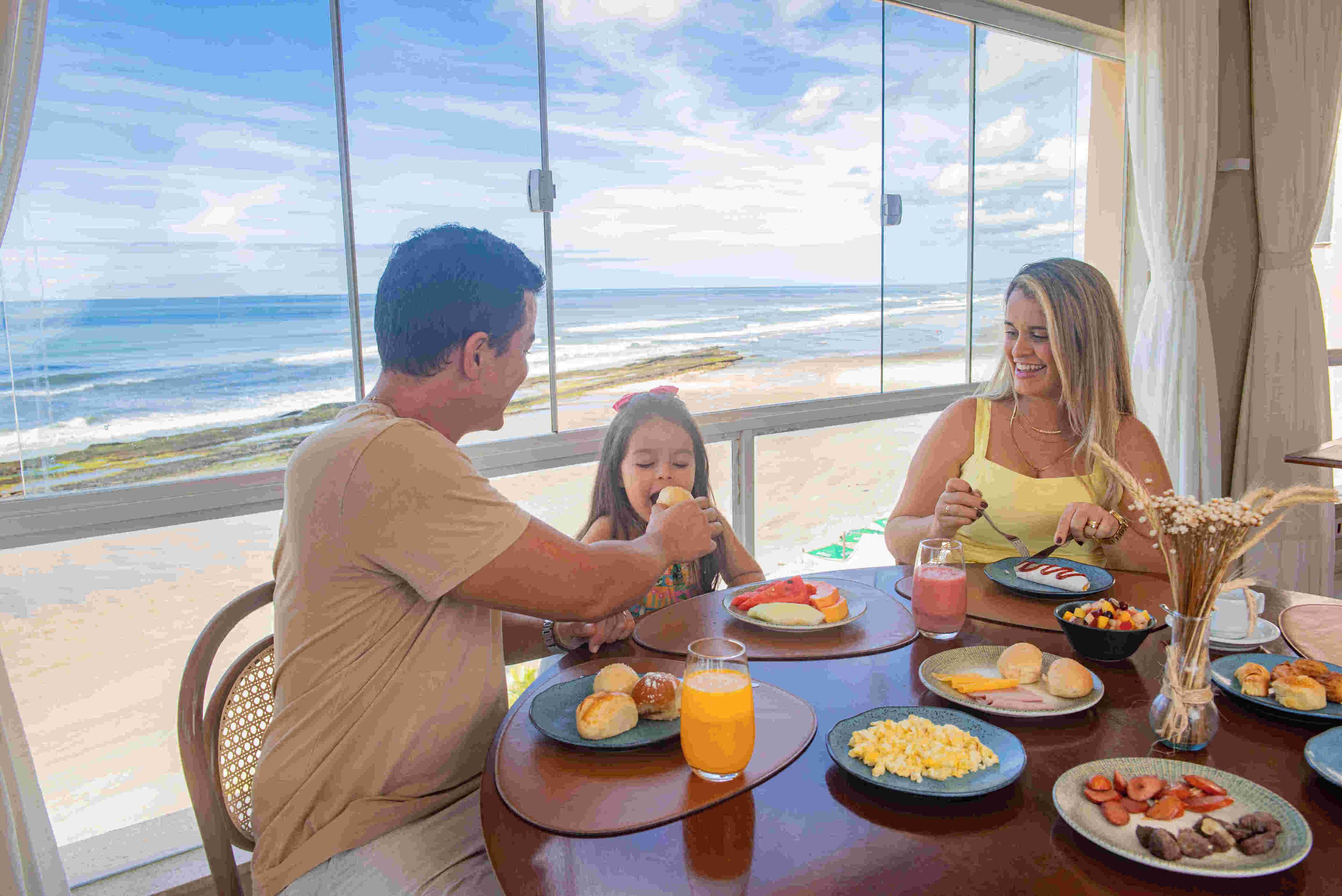A family dining at a table with a view of the ocean.