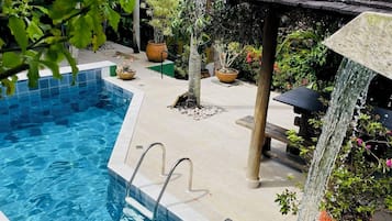 Alberca al aire libre y camastros