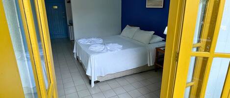 Quarto com uma cama, parede azul e porta com detalhes amarelos.