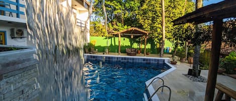Una piscina al aire libre, tumbonas