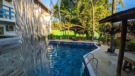 Una piscina al aire libre, sillones reclinables de piscina