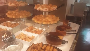 En buffet med forskellige bagværk og en kage på et hvidt bord.