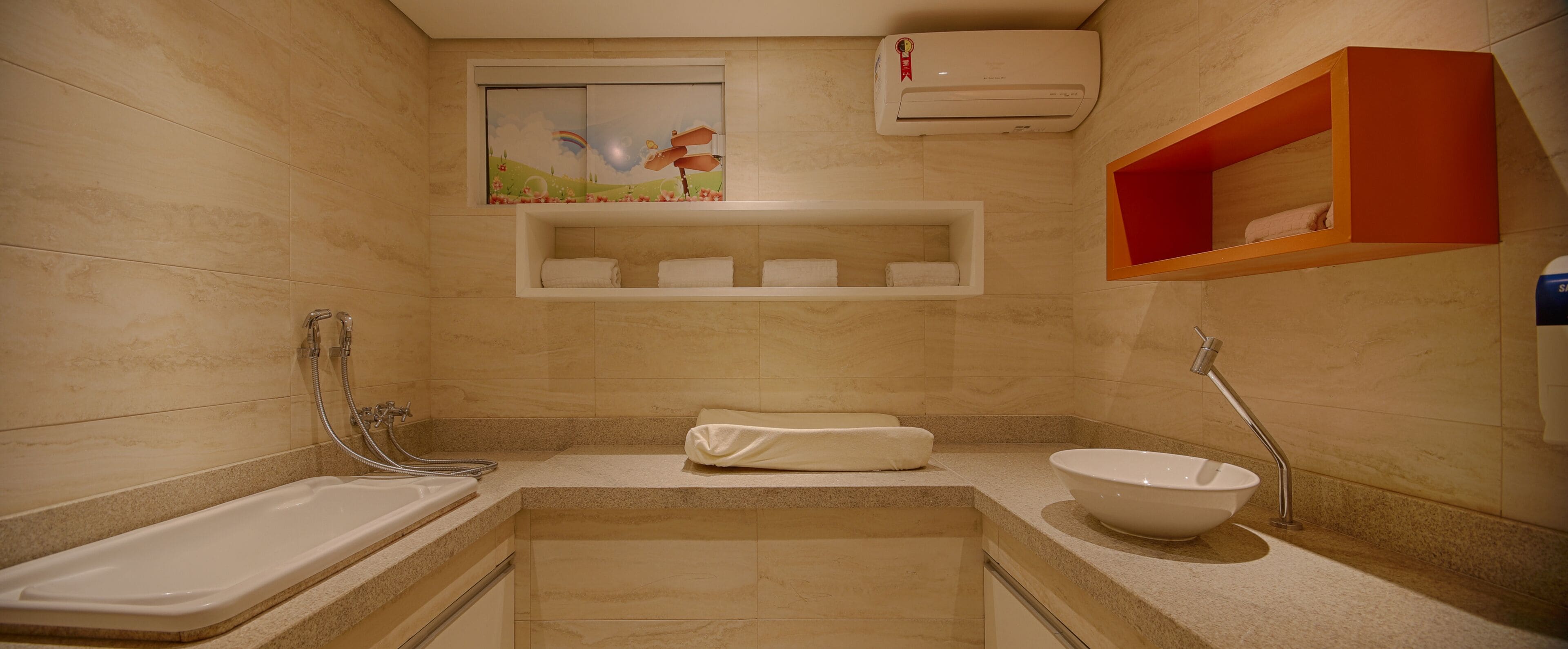 A bathroom with a bathtub, sink, and a shelf with towels.