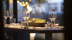 A dining table set with wine glasses, a bowl of greens, and a water glass. - Four Seasons Residence Club Aviara, North San Diego (Carlsbad)