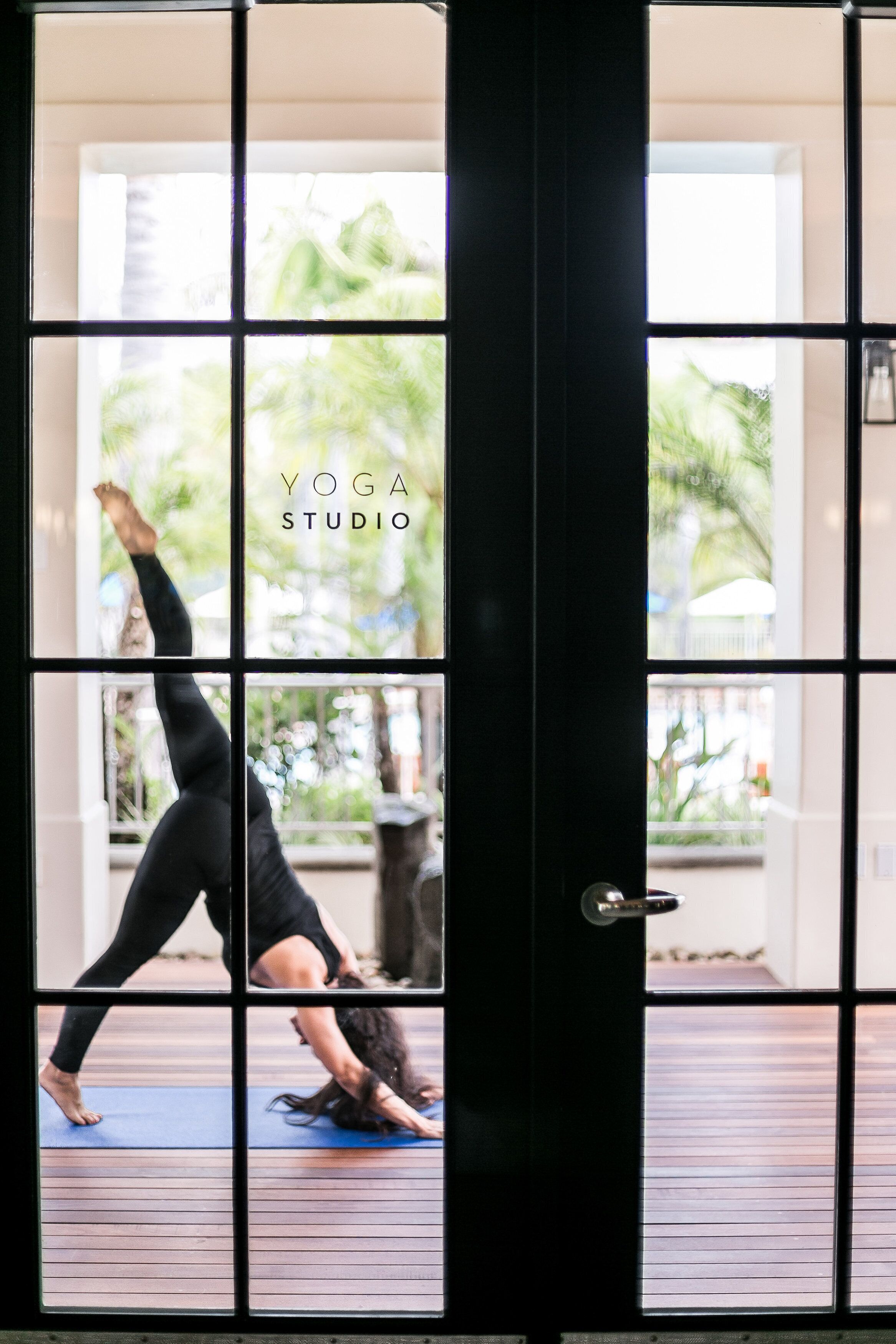 A yoga studio with a large window and a black door.
