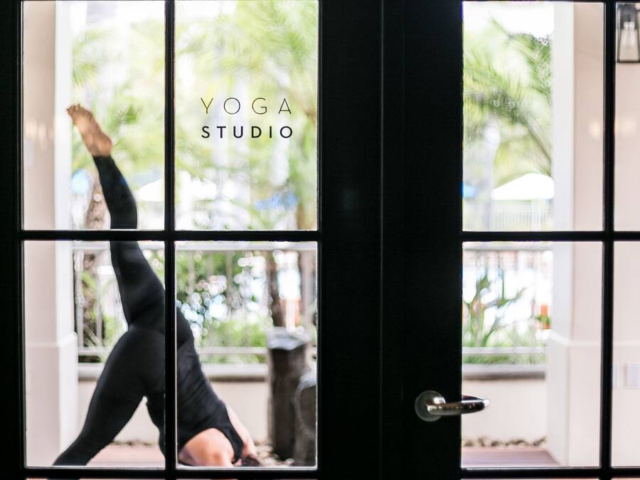 A yoga studio with a large window and a black door.