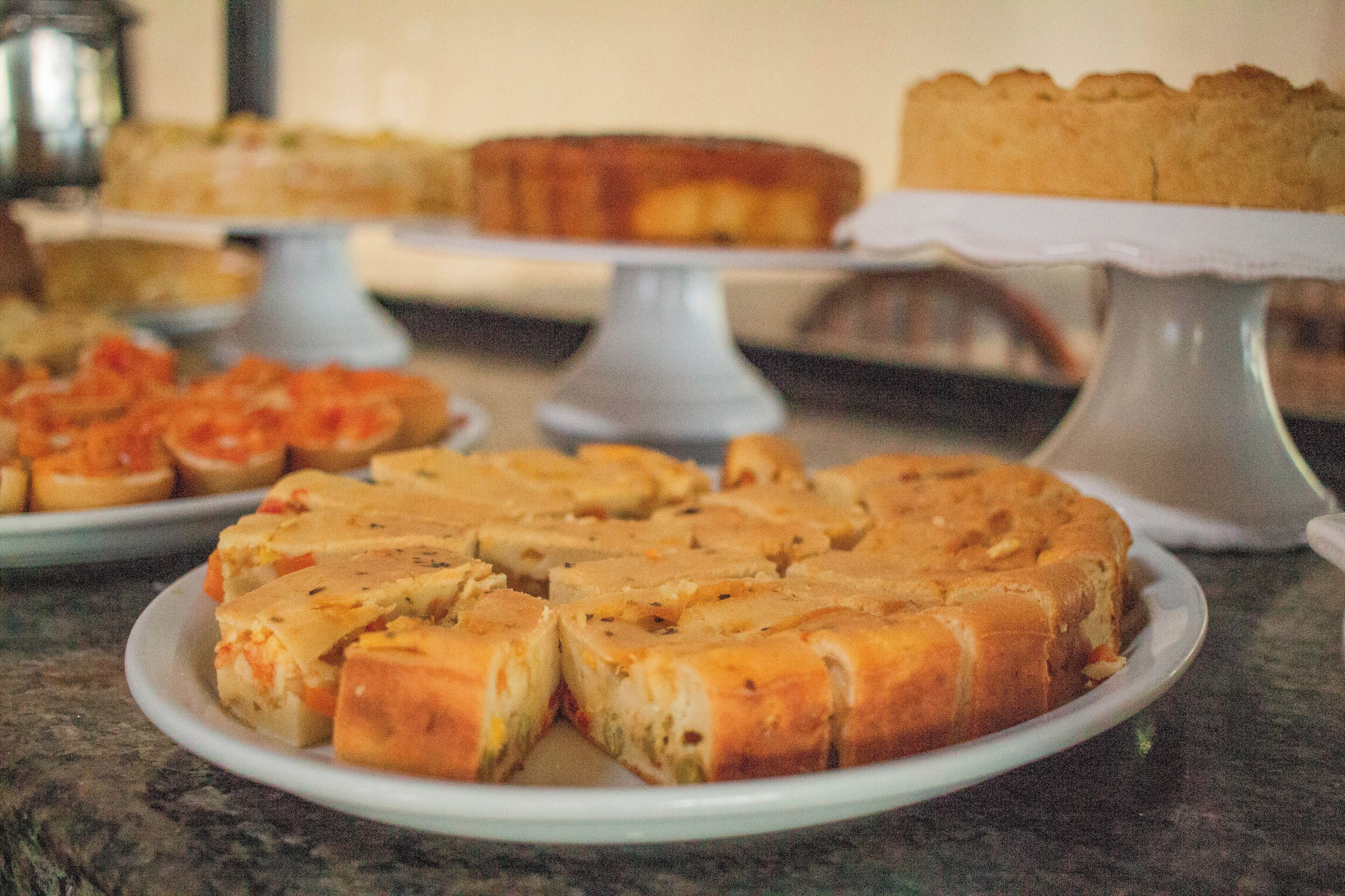Variedad de productos horneados a la vista, incluyendo un pastel y varios tipos de pan.