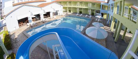 Una piscina al aire libre, sillones reclinables de piscina