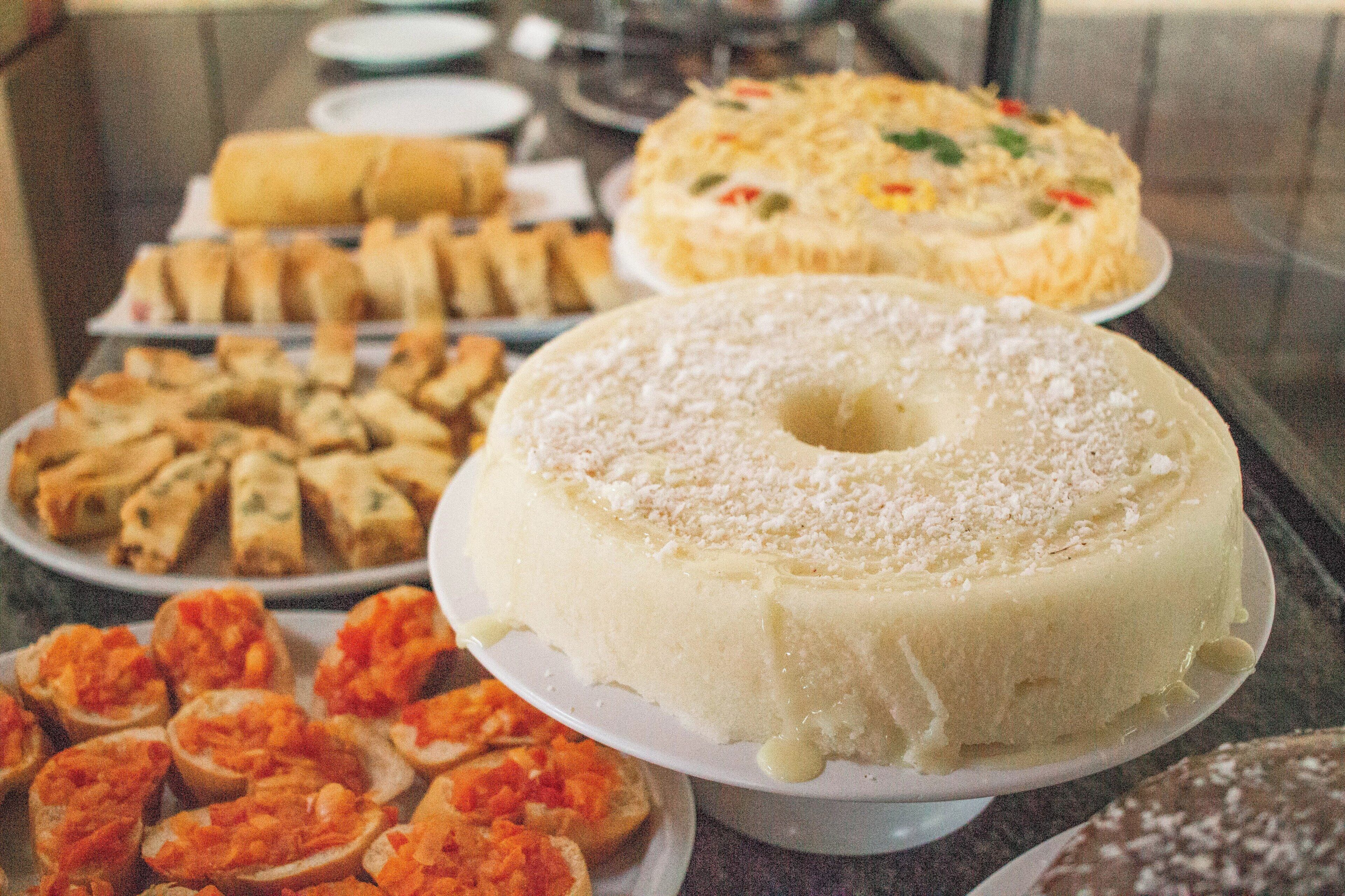 A buffet with various dishes including a large white cake, shrimp, and other food items.