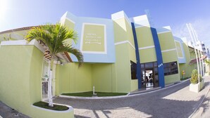 A modern hotel with a green facade, a palm tree, and a clear blue sky. - Hotel Parque das Águas (Aracaju)